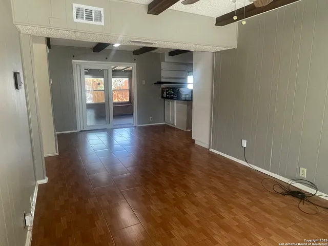 a view of a hallway with wooden floor and a cabinet