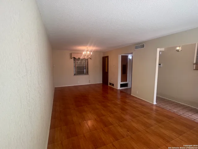 a view of empty room with wooden floor