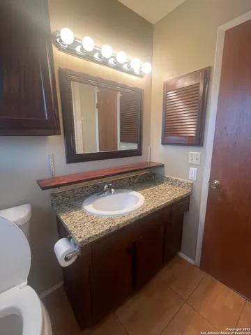 a bathroom with a granite countertop sink and a mirror
