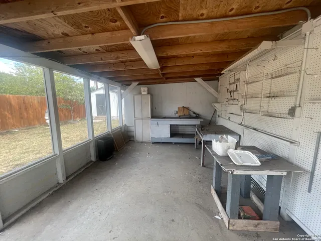 a view of backyard with barbeque grill and wooden fence