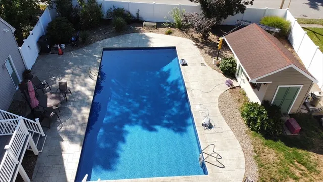 a view of a white house with a yard table and chairs