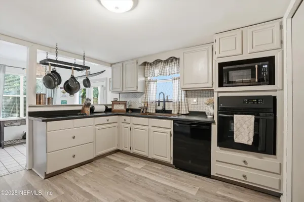 a kitchen with granite countertop cabinets stainless steel appliances and a window