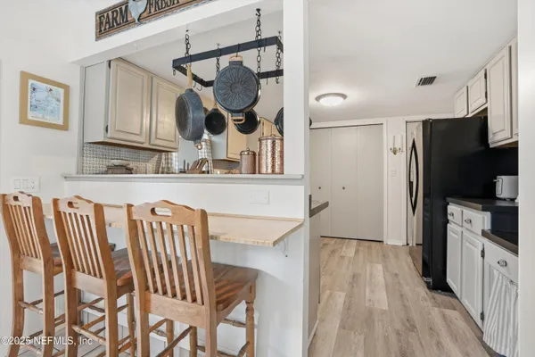 a kitchen with stainless steel appliances wooden floor and chairs