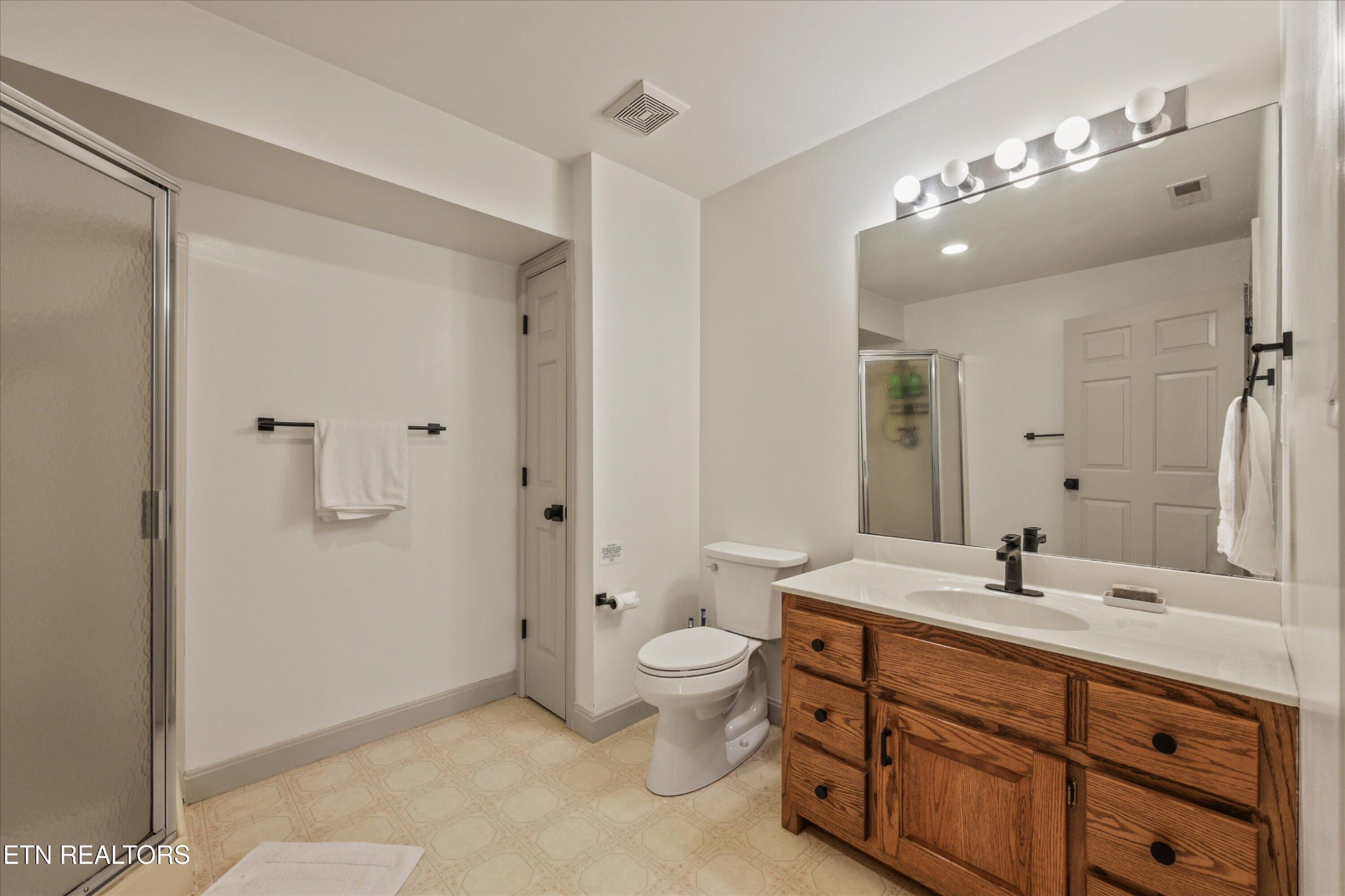 257 Lone Ridge Lane Heiskell, TN 37754 - Photo 45 of 60 a bathroom with a double vanity sink toilet mirror and shower