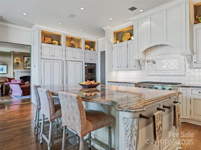 a kitchen with stainless steel appliances granite countertop a stove top oven a sink and a refrigerator