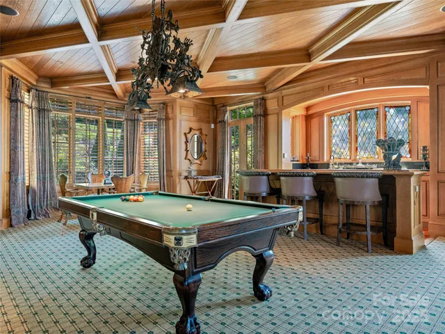 a room with pool table and windows