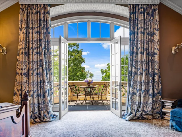a view of a porch with chairs and floor to ceiling window