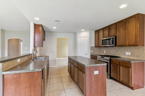 a kitchen with stainless steel appliances granite countertop a sink stove and refrigerator