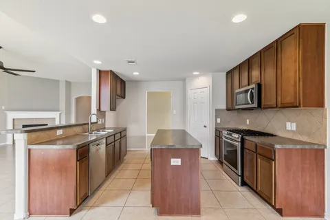a kitchen with stainless steel appliances granite countertop a stove a sink and a refrigerator