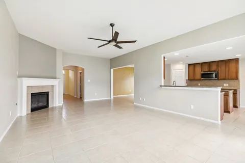 a view of a livingroom with a fireplace a sink and a ceiling fan