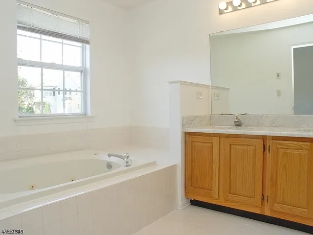 a spacious bathroom with a granite countertop tub sink and mirror