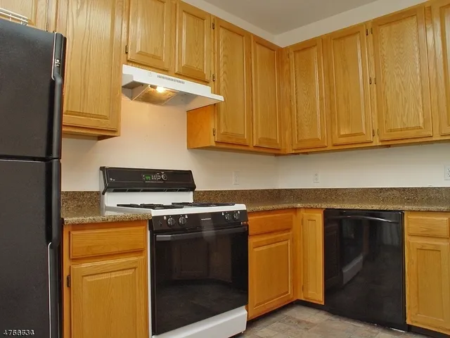 a kitchen with stainless steel appliances granite countertop cabinets and a refrigerator