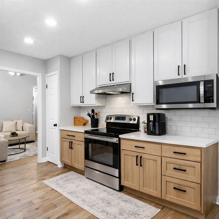 237 Mona Place Dallas, GA 30132 - Photo 3 of 28 a kitchen with cabinets stainless steel appliances and wooden floor