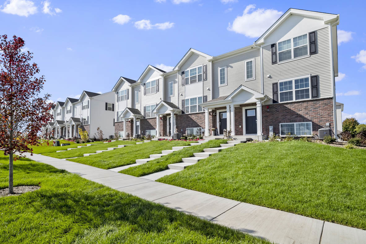 a view of a building next to a big yard and large trees