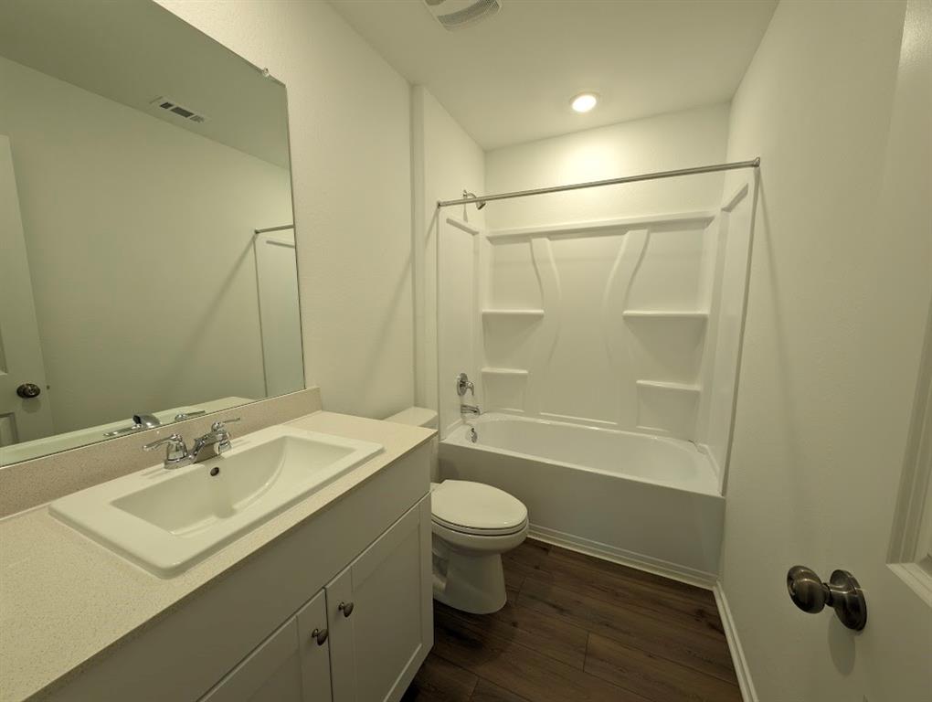 564 Rancho Del Cielo Loop Jarrell, TX 76537 - Photo 7 of 14 A well-appointed bathroom features a single vanity, a spacious mirror, and a convenient tub/shower combination.