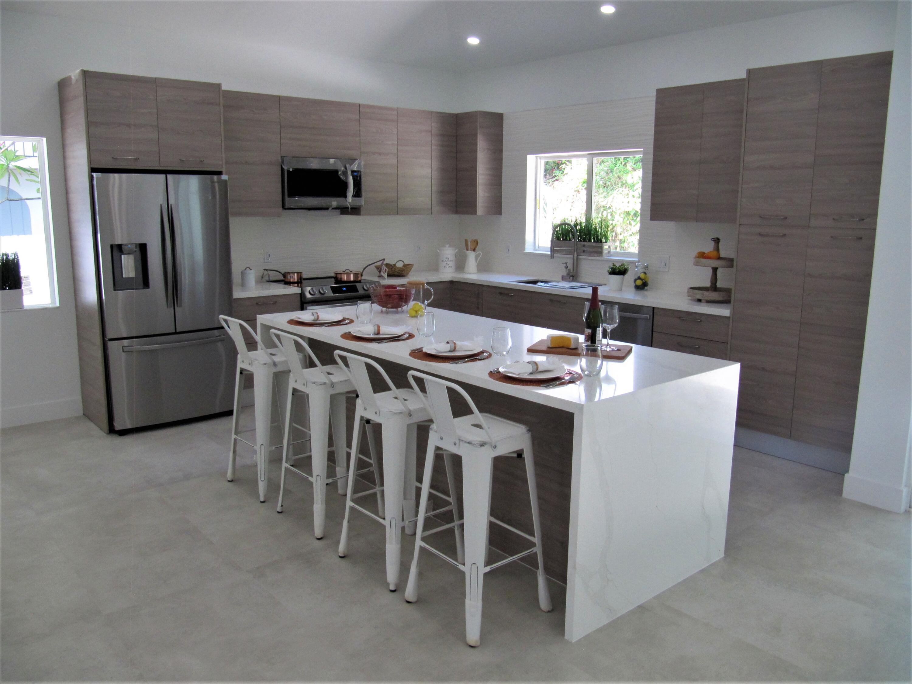 441 4th Road Key Largo, FL 33037 - Photo 6 of 18 a kitchen with stainless steel appliances a table chairs refrigerator and microwave