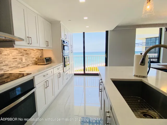 a kitchen with stainless steel appliances granite countertop a sink a stove and a refrigerator