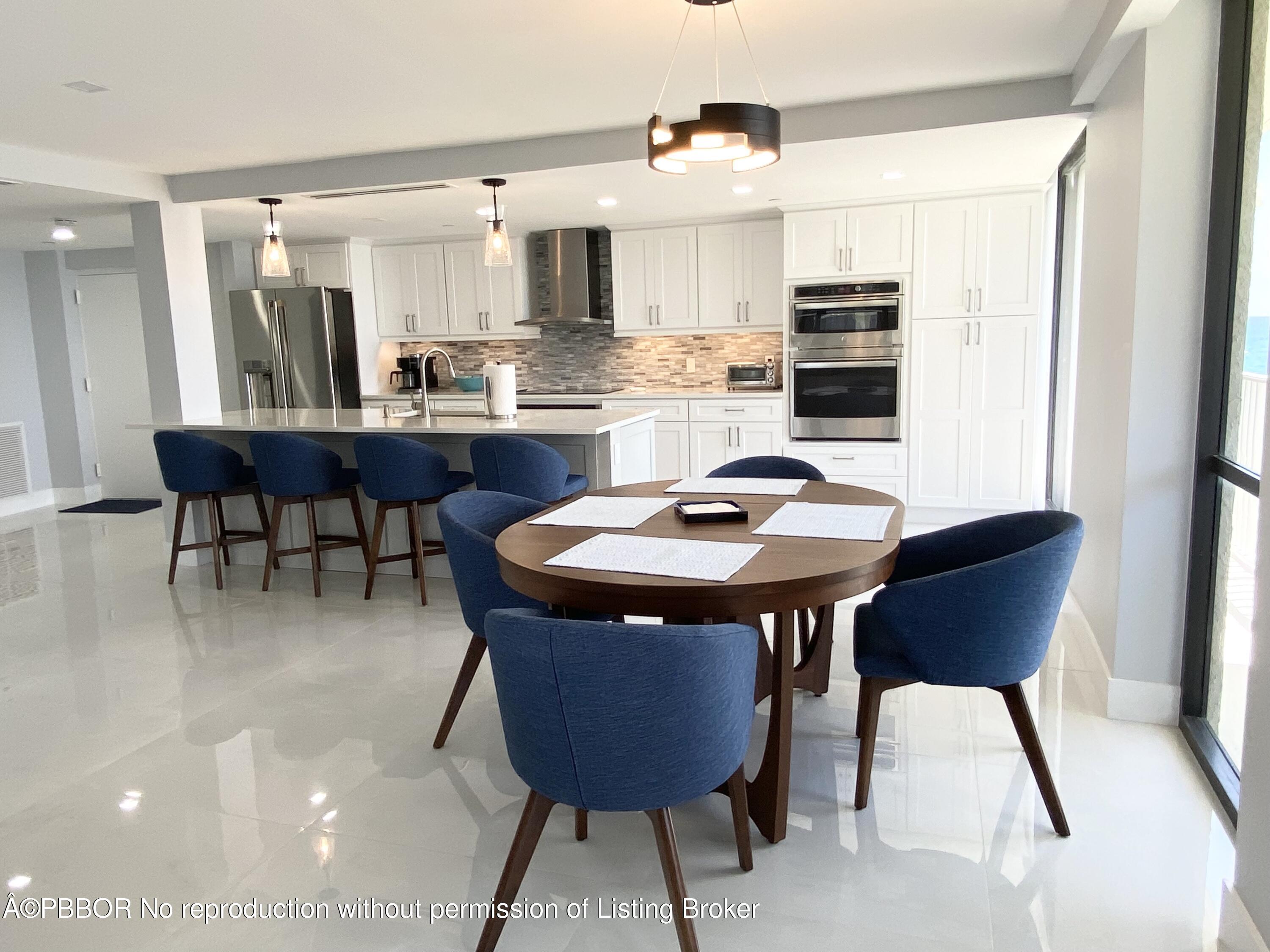 3360 South Ocean Boulevard, Unit 4FII Palm Beach, FL 33480 - Photo 14 of 32 a kitchen with stainless steel appliances kitchen island granite countertop a table chairs sink and cabinets