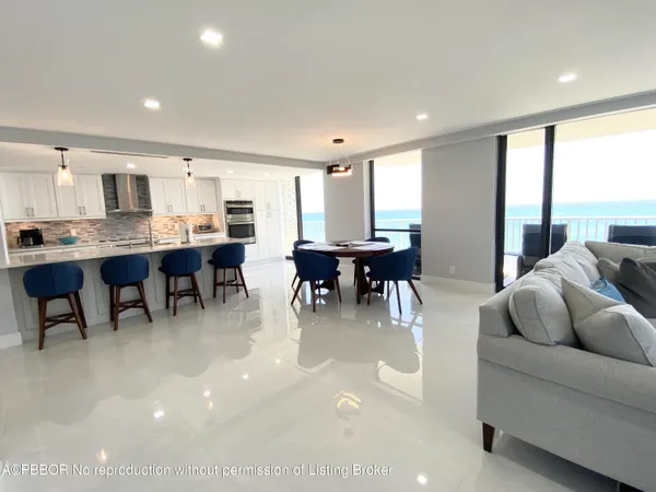 a living room with furniture a dining table and a large window