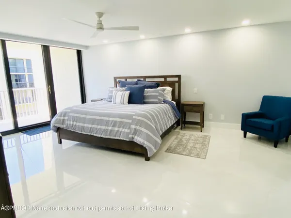 a bedroom with a bed a couch and large window