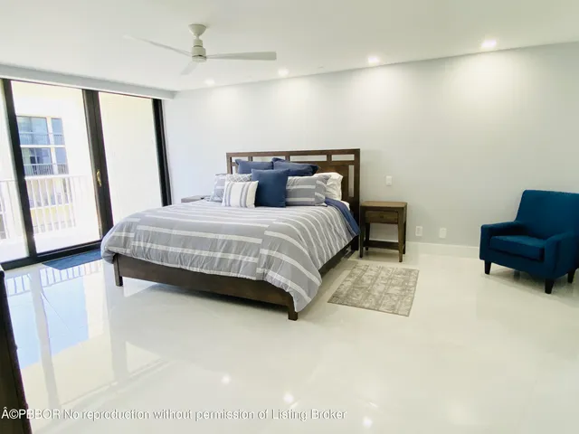 a bedroom with a bed a couch and large window