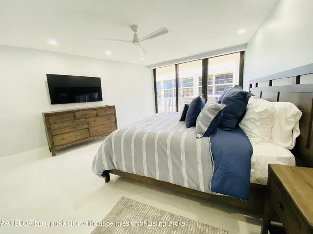 a bedroom with a large bed and a flat tv screen on dresser