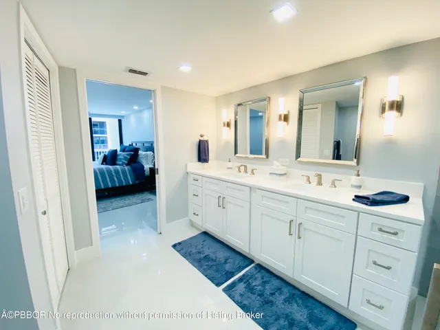 a spacious bathroom with a double vanity sink and mirror