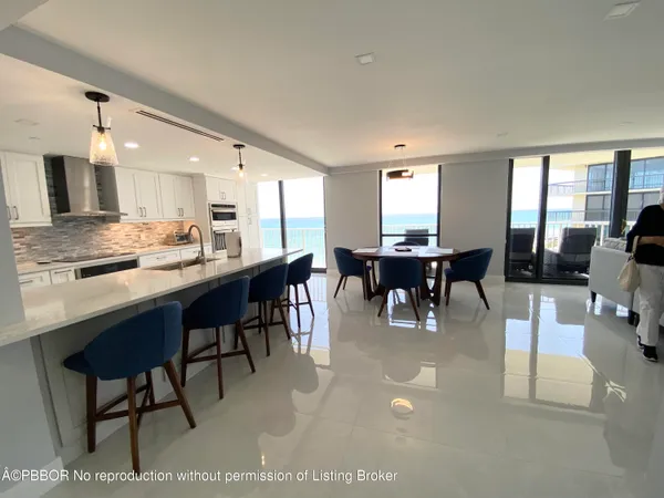 a dining hall with stainless steel appliances kitchen island granite countertop furniture and a large window