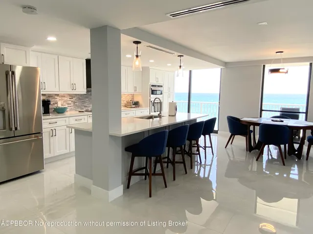 a kitchen with a dining table chairs appliances and a window