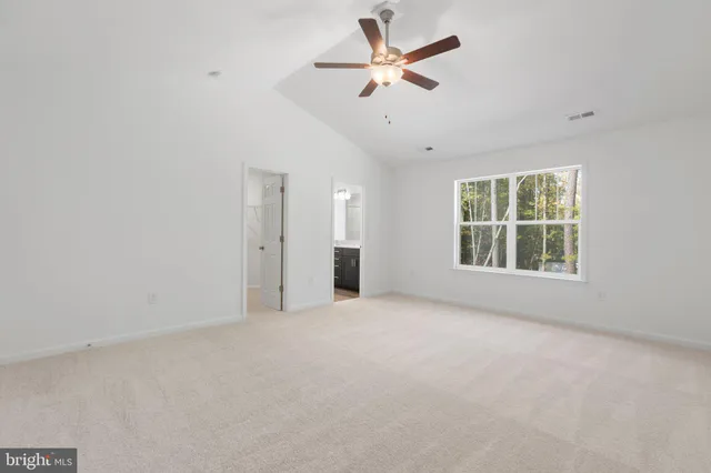 an empty room with a window and a fan