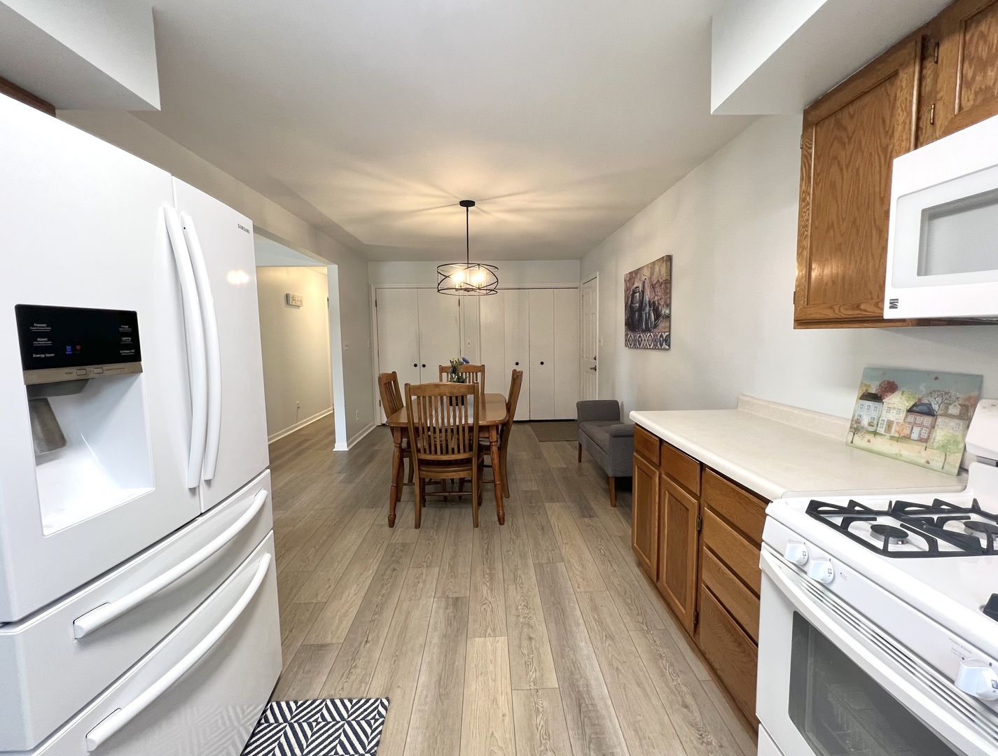 1201 Clark Street Rantoul, IL 61866 - Photo 13 of 24 a kitchen with stainless steel appliances a dining table chairs and a refrigerator