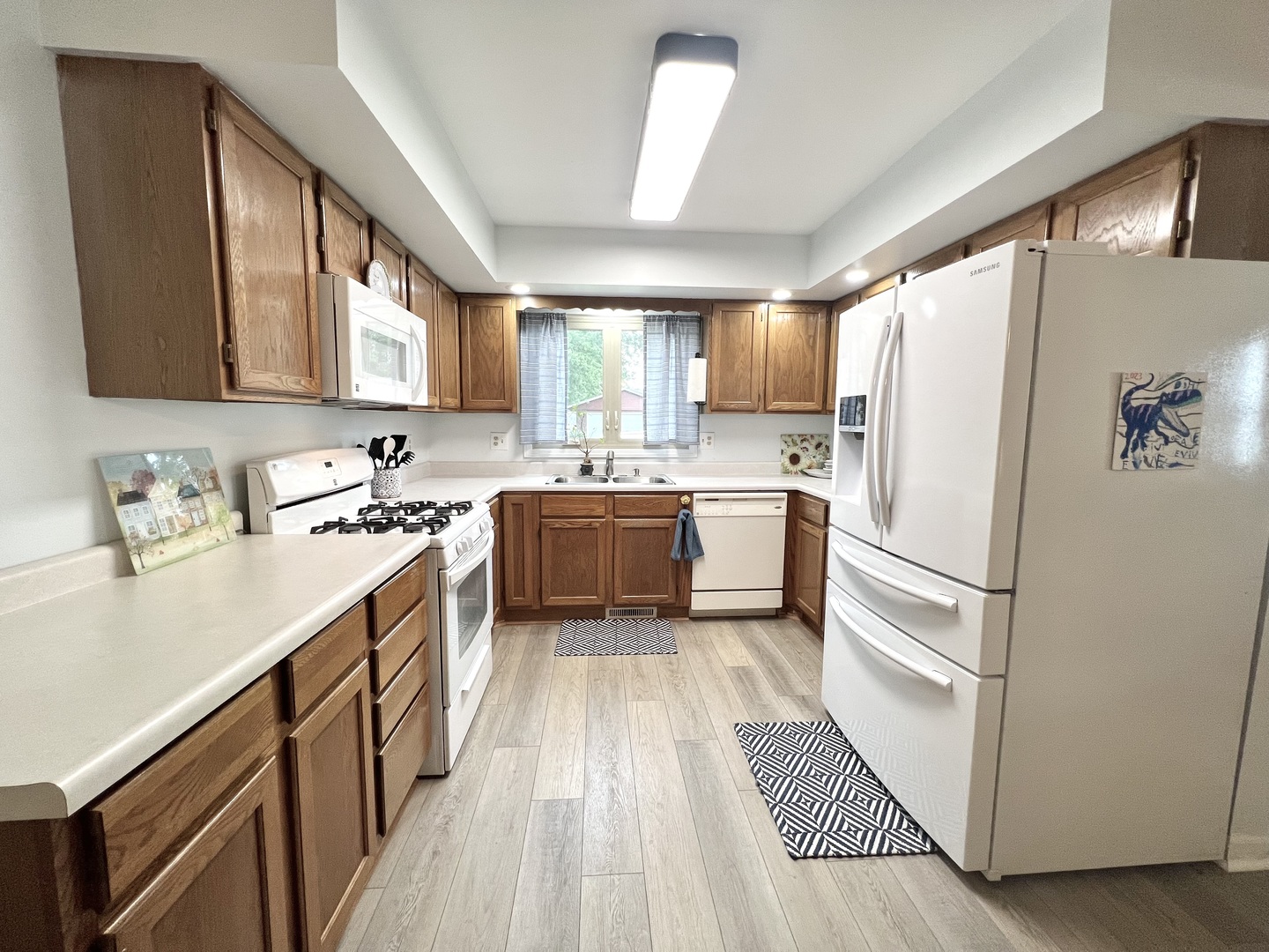 1201 Clark Street Rantoul, IL 61866 - Photo 9 of 24 a kitchen with a sink a window a refrigerator and stainless steel appliances
