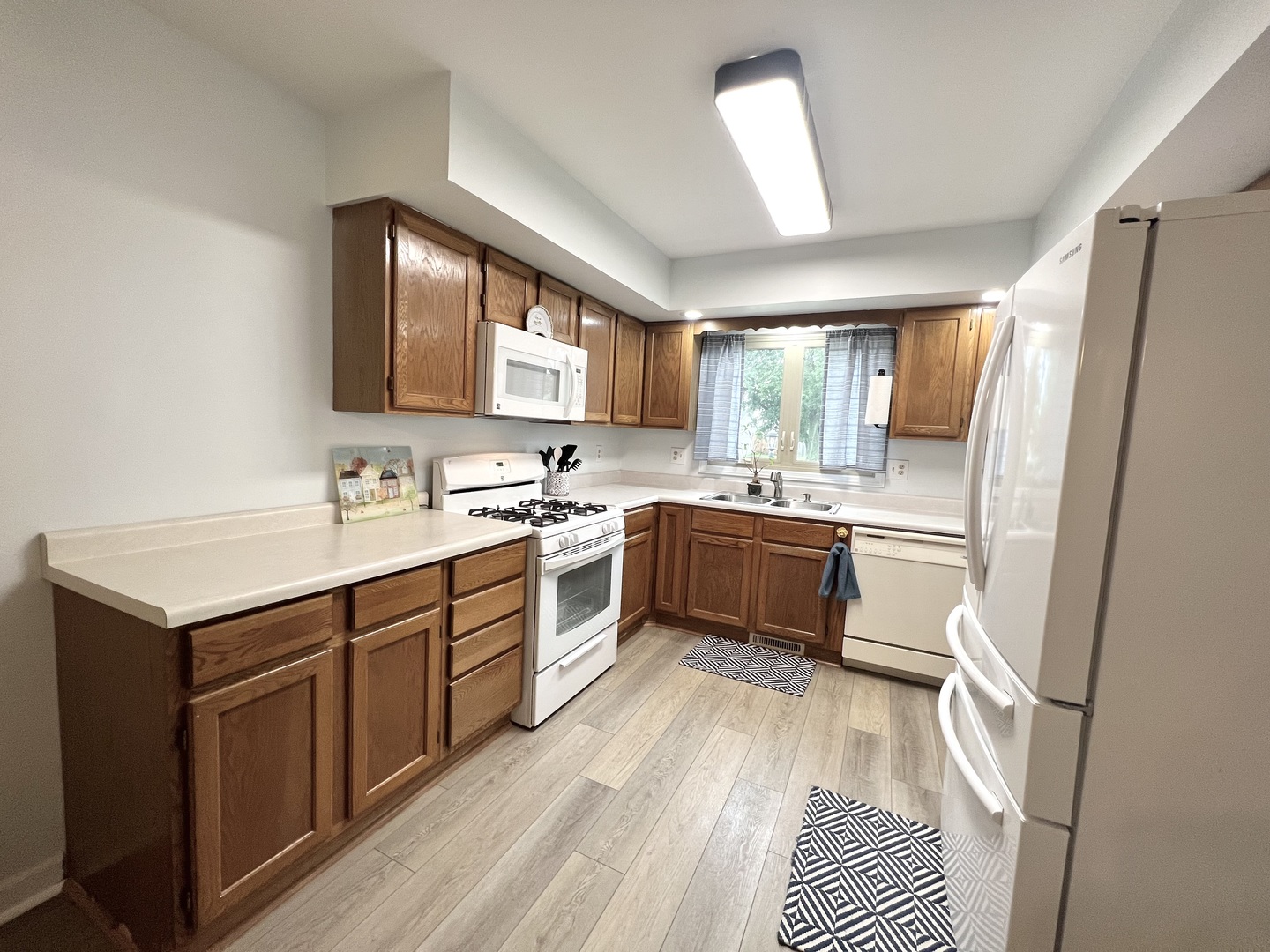 1201 Clark Street Rantoul, IL 61866 - Photo 10 of 24 a kitchen with a sink window and white stainless steel appliances