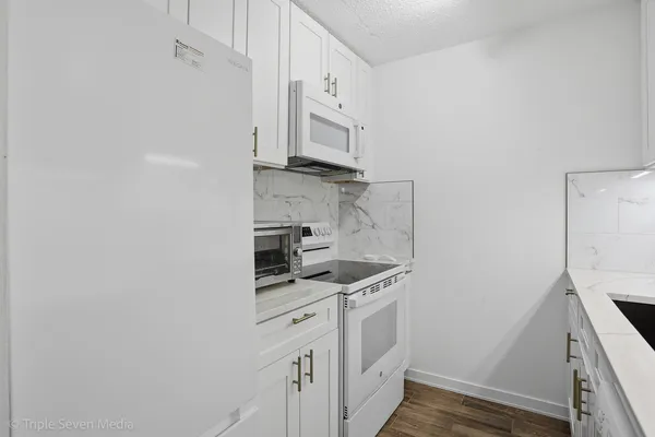 a kitchen with stainless steel appliances a sink stove and cabinets
