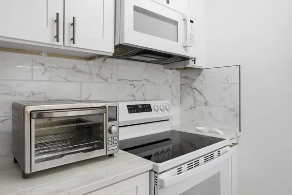 a stove top oven sitting inside of a kitchen