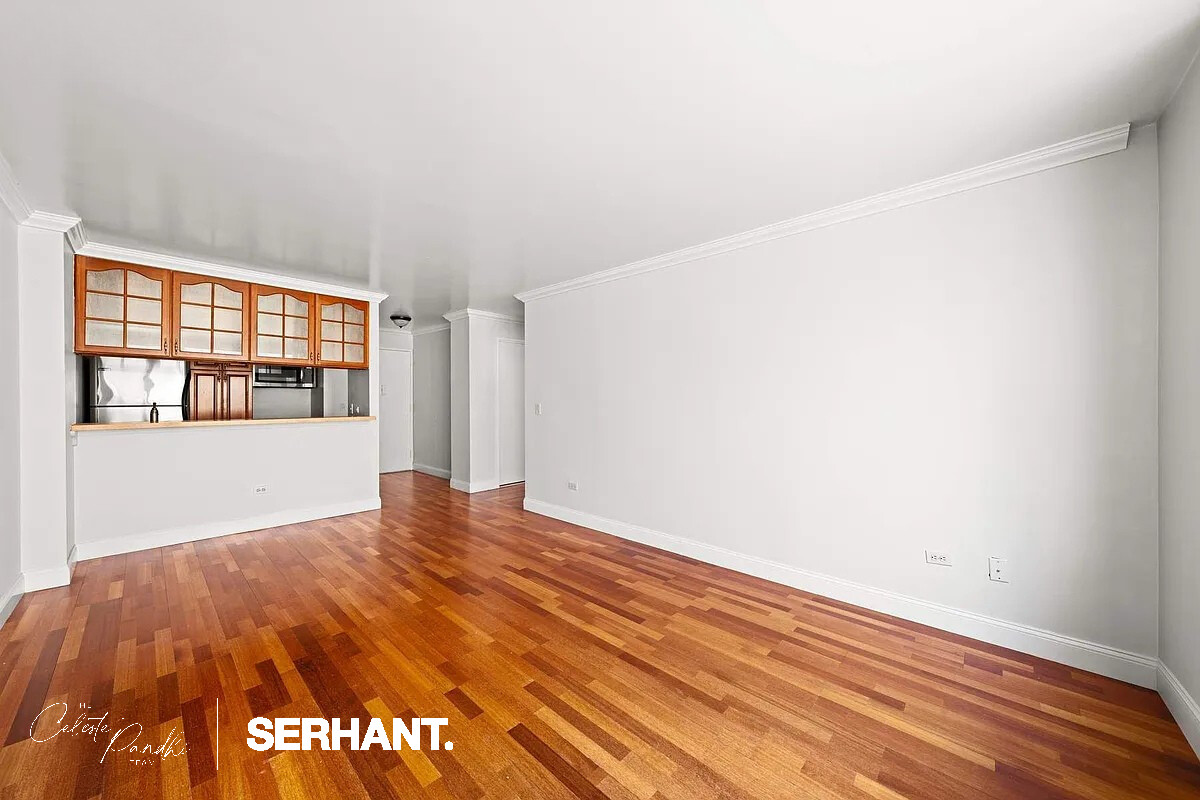2 South End Avenue, Unit 6J Manhattan, NY 10280 - Photo 4 of 19 a view of an empty room with wooden floor and a window