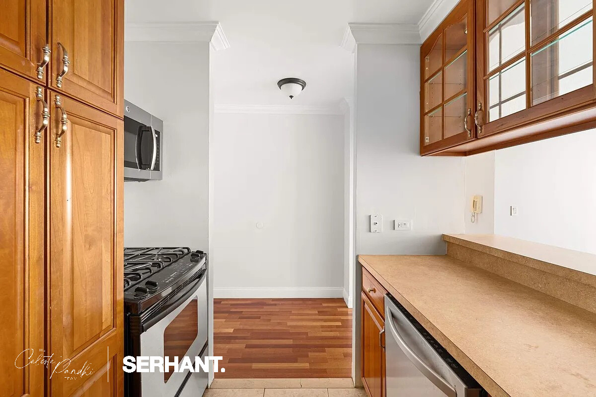 2 South End Avenue, Unit 6J Manhattan, NY 10280 - Photo 6 of 19 a kitchen with a stove and a refrigerator