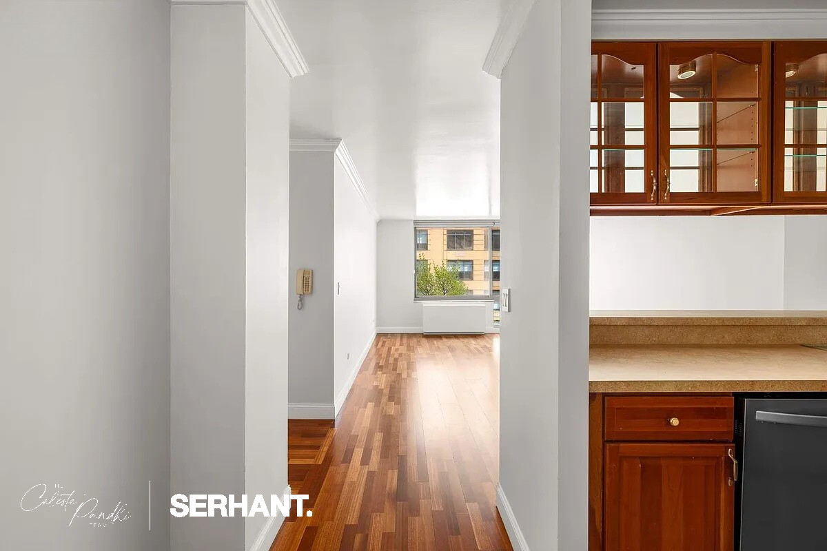2 South End Avenue, Unit 6J Manhattan, NY 10280 - Photo 7 of 19 a view of a hallway with wooden floor and staircase