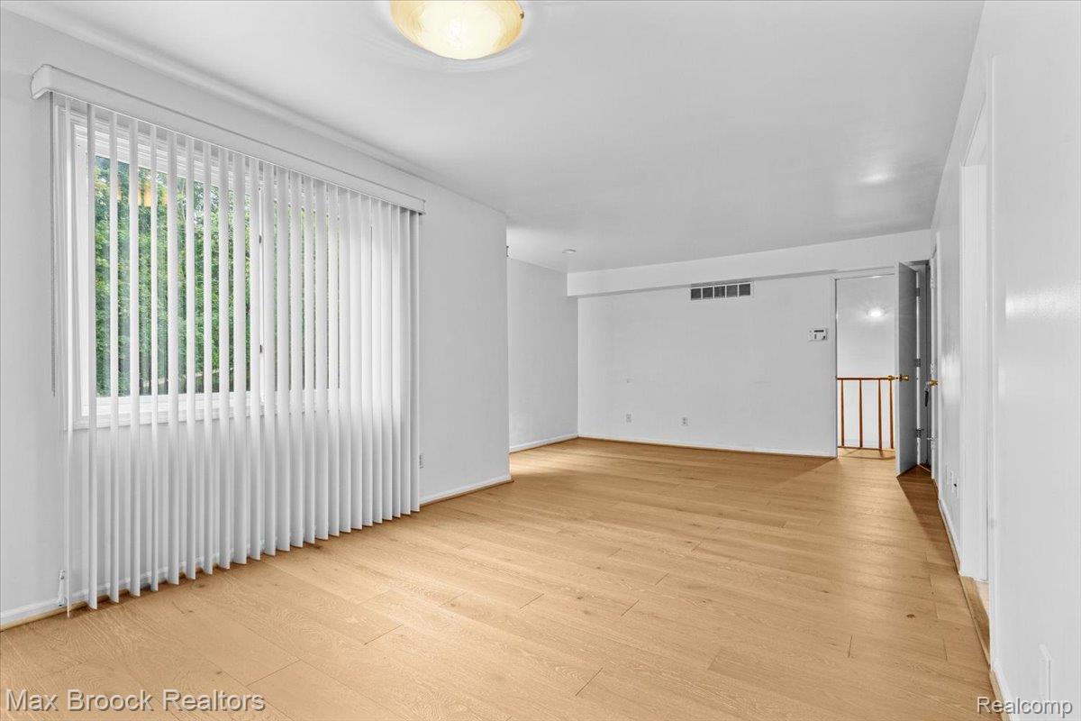 1830 Lone Pine Road Bloomfield Hills, MI 48302 - Photo 34 of 70 Spacious room featuring light wood-finish flooring, a large window with vertical blinds, and a flush mount ceiling light