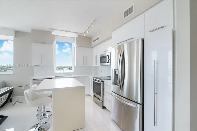 a kitchen with stainless steel appliances a refrigerator sink and stove