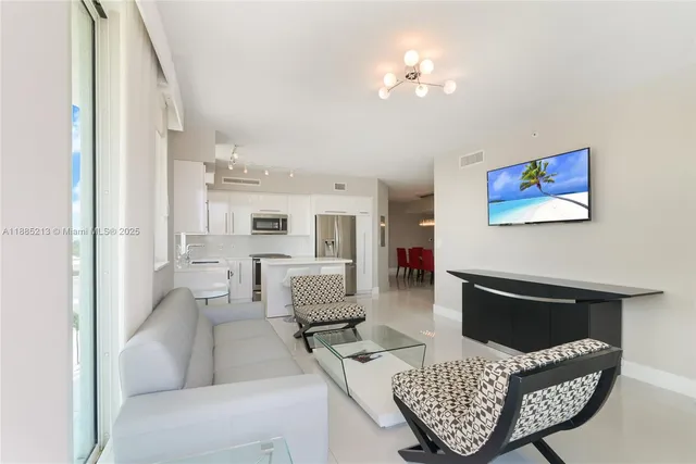 a living room with furniture a fireplace and a chandelier