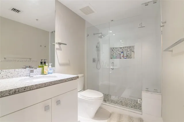 a bathroom with a sink a toilet and shower
