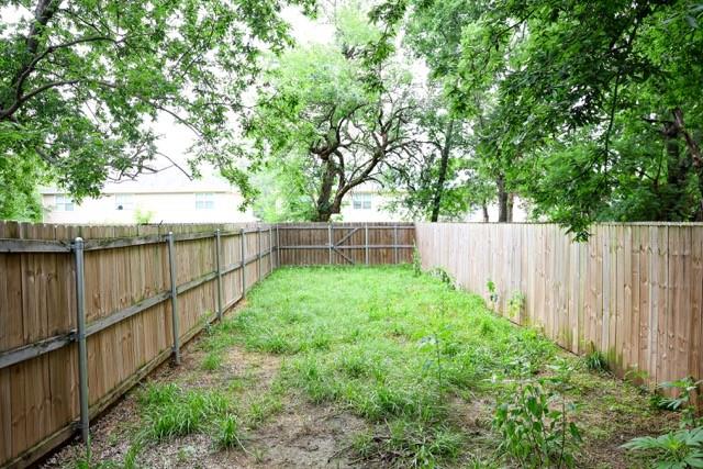 802 South 5th Street, Unit 1 Bonham, TX 75418 - Photo 7 of 25 Enclosed backyard featuring natural wood fencing and a grassy area