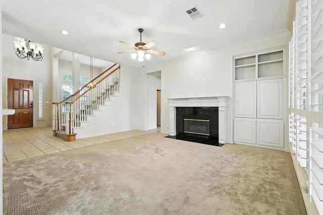 a view of empty room with fireplace and fan