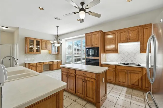 a kitchen with stainless steel appliances granite countertop a sink and a refrigerator
