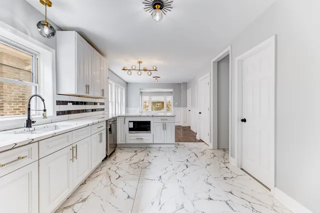 a kitchen with granite countertop a sink stove and cabinets