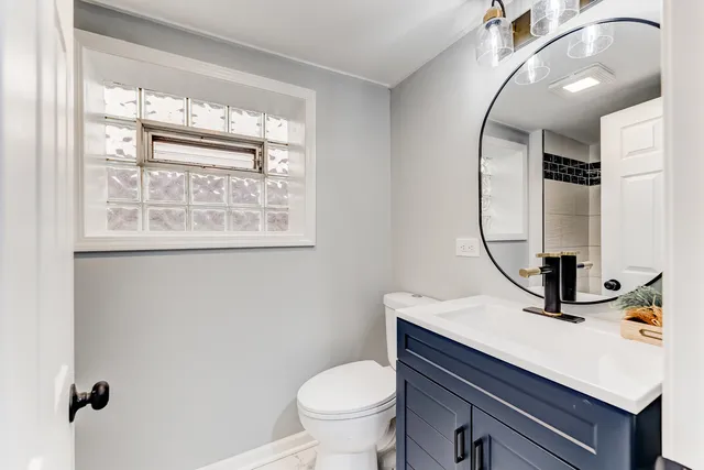 a bathroom with a sink a toilet and mirror