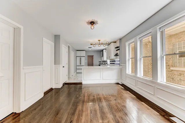 a view of a kitchen with wooden floor and a window