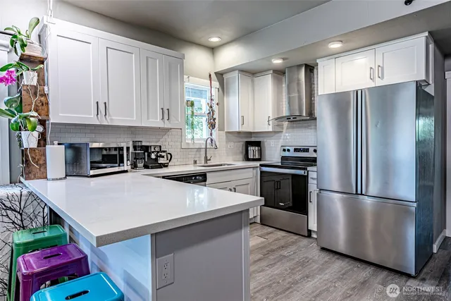 a kitchen with a refrigerator a stove a microwave and cabinets