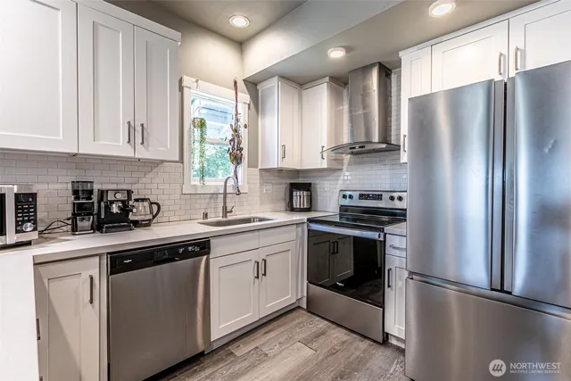 a kitchen with stainless steel appliances granite countertop a refrigerator sink and cabinets